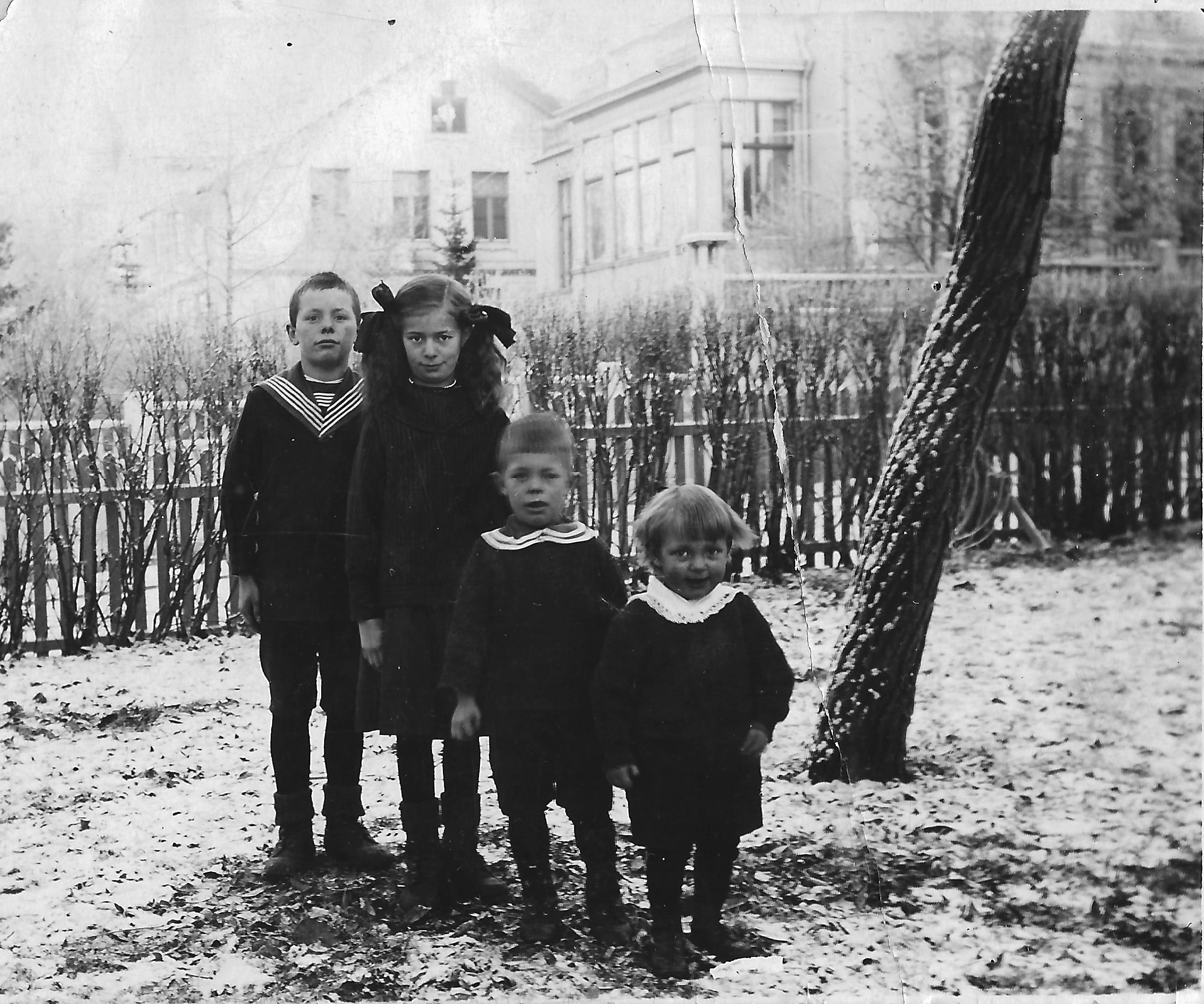 Farmors syskon Alfred (1908-1974), Wivan (1910-2001), Gustaf (1915-1995) och Stig (1918-2007) framför hemmet på Strandgatan 5 i Östersund (Z) c. 1920. Huset revs 1962.